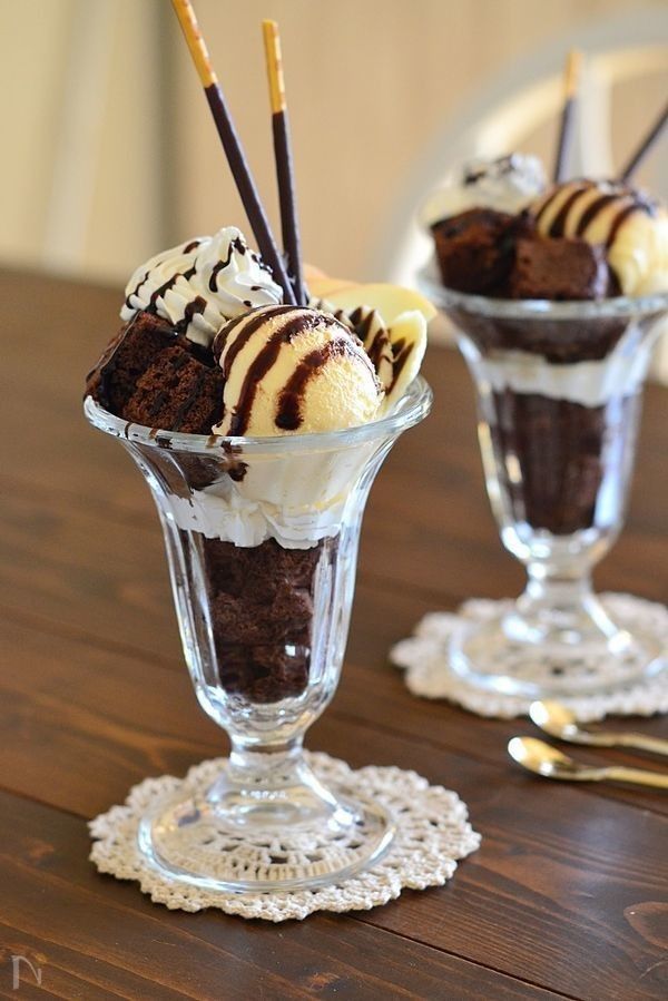 two glasses filled with ice cream on top of a wooden table