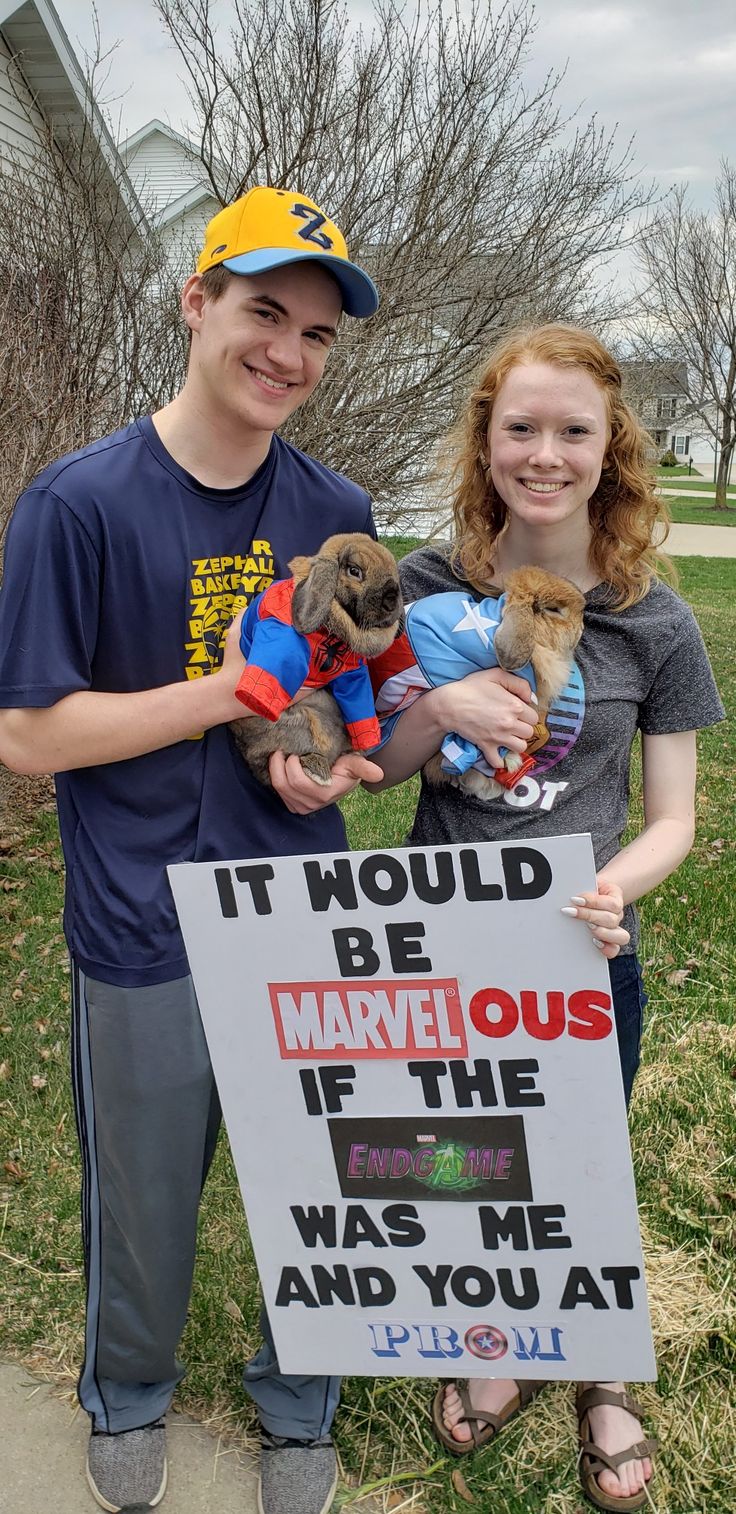 two people holding stuffed animals in front of a sign that says it would be marvelous if the dog was me and you at least one