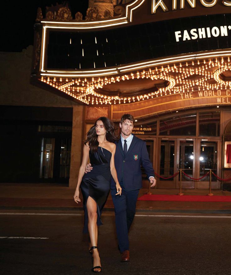 a man and woman are walking in front of a fashion's night out sign