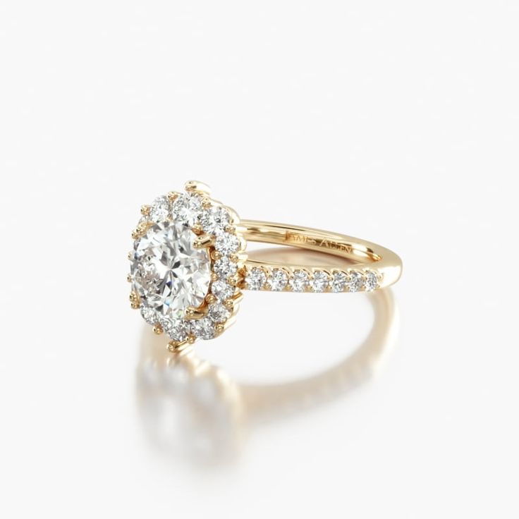 a yellow gold engagement ring with an oval cut diamond surrounded by small round brilliant diamonds