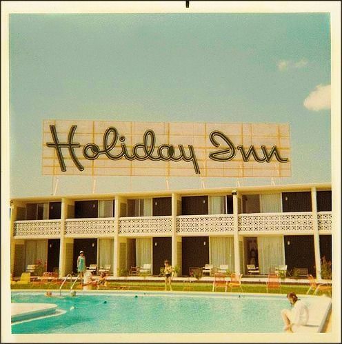 an old photo of a hotel with a swimming pool