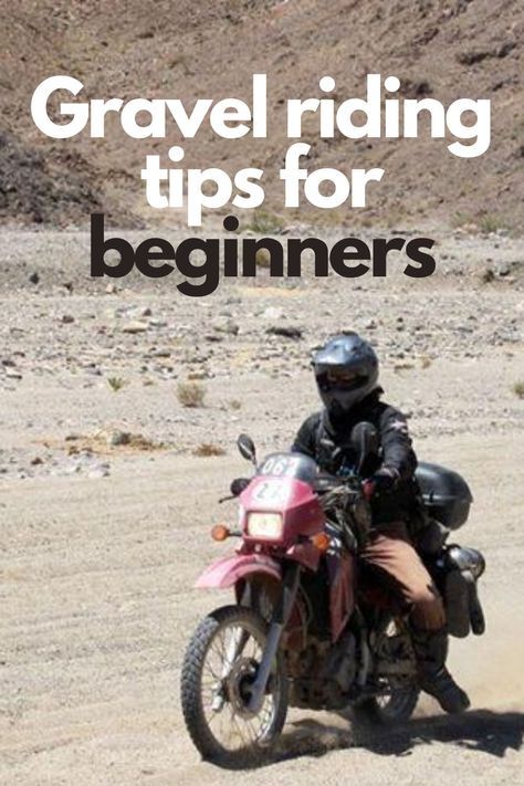 a man riding on the back of a pink motorcycle down a dirt road next to a mountain