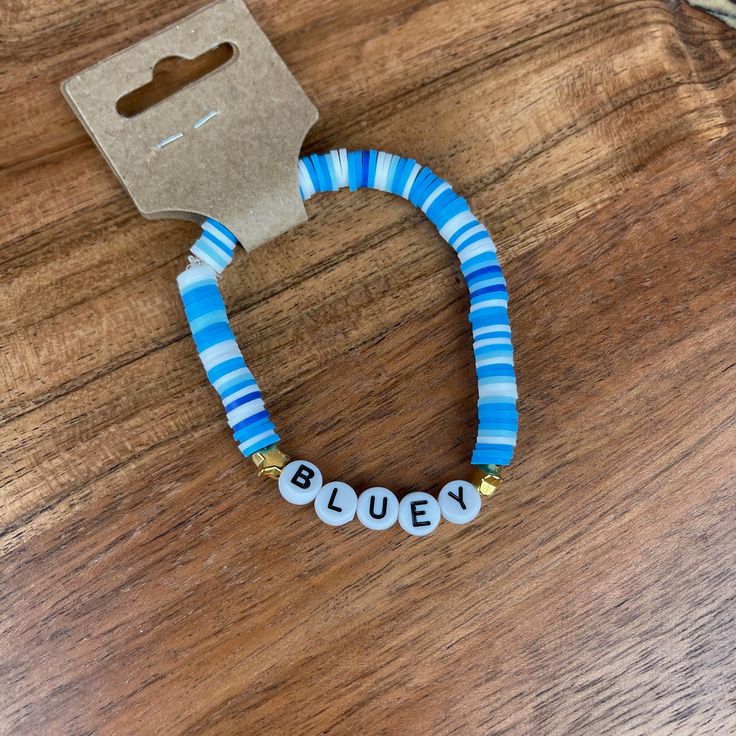 a blue and white beaded bracelet with the word busy written in small letters on it