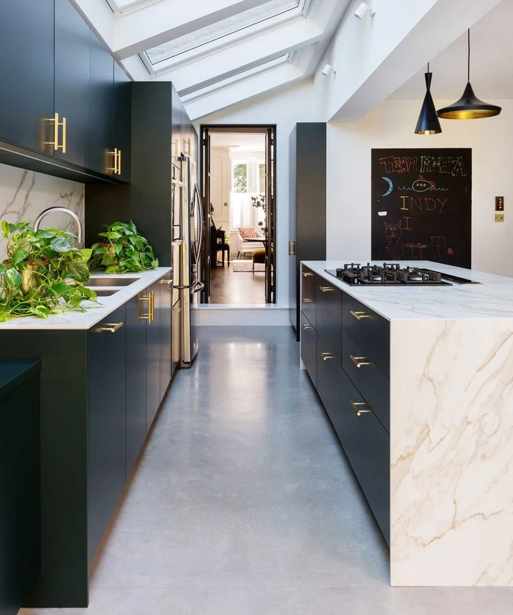 a kitchen with marble counter tops and black cabinets