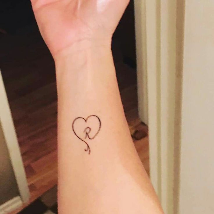 a woman's arm with a heart tattoo on it