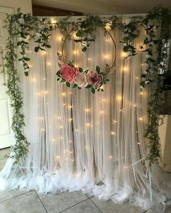 a white curtain with flowers and lights hanging from it