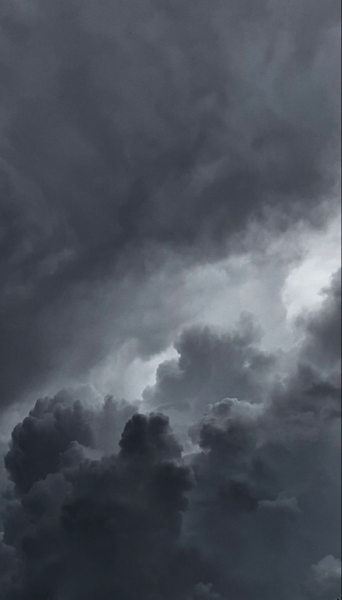 an airplane is flying in the sky with dark clouds behind it and one plane has just taken off