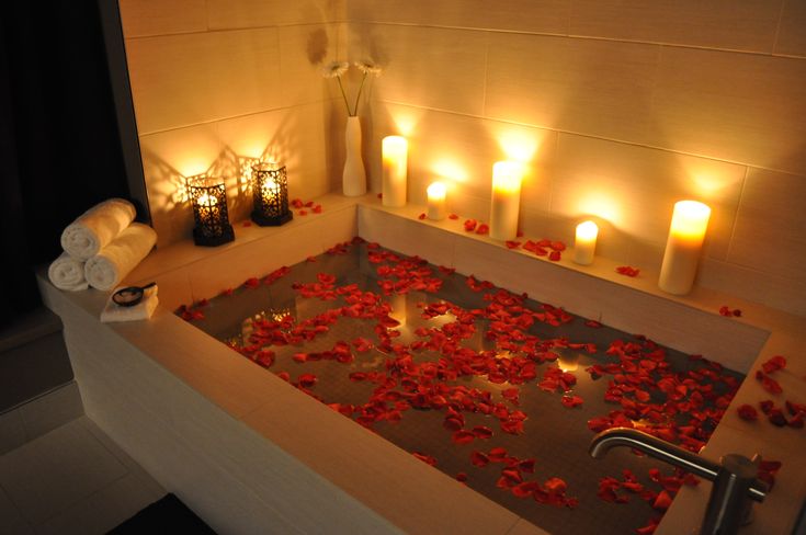 a bathtub filled with candles and rose petals