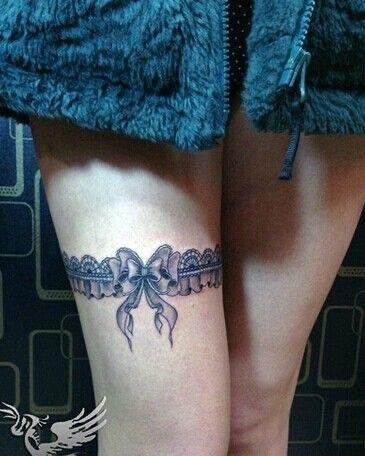 a woman's leg with a bow tattoo on it