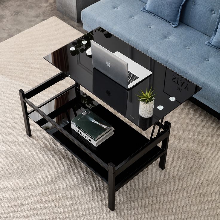 a coffee table with a laptop on it in the middle of a living room area