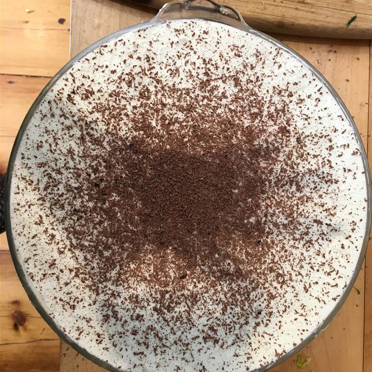 a cake with chocolate sprinkles on it sitting on top of a wooden table