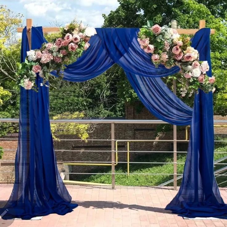 an outdoor ceremony with blue drapes and flowers