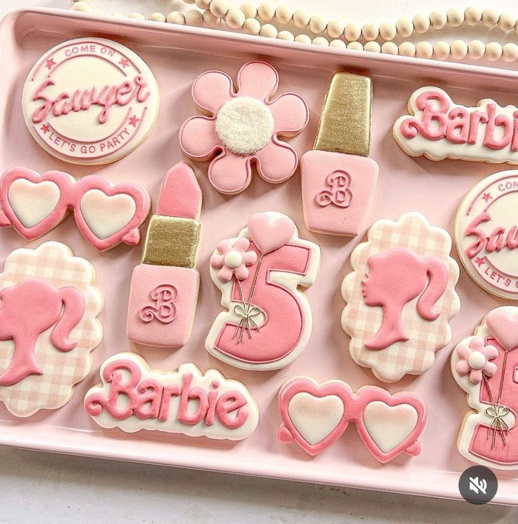 pink and white decorated cookies in a pink tray with name tags, bow, flowers, hearts, number five