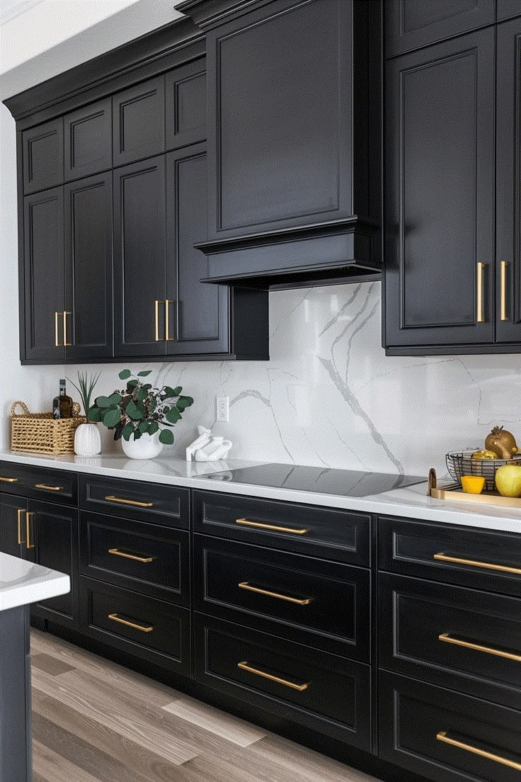 a kitchen with black cabinets and white marble counter tops, gold trimmings on the backsplash