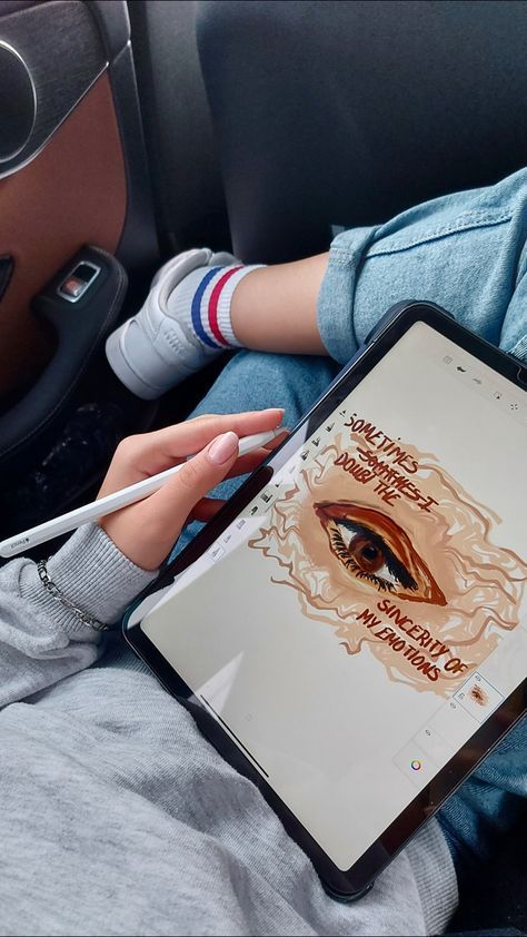 a person sitting in a car holding a tablet with an eye drawn on the screen