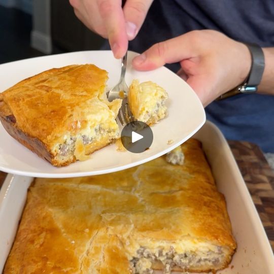 a person is cutting into a casserole on a plate with a knife and fork