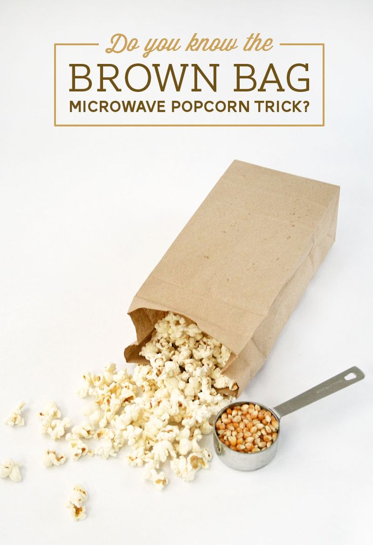 a brown paper bag filled with popcorn next to a spoon