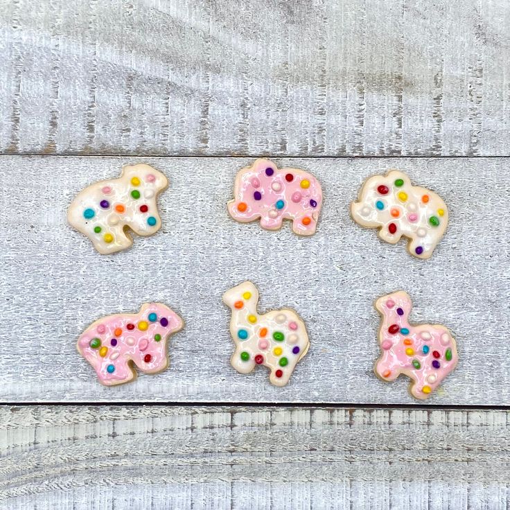 four decorated cookies sitting on top of a wooden table