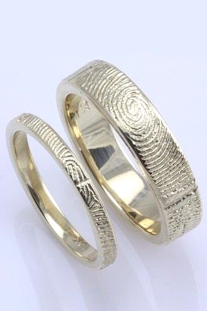 two gold wedding rings with fingerprints on each ring, one in the shape of a fingerprint