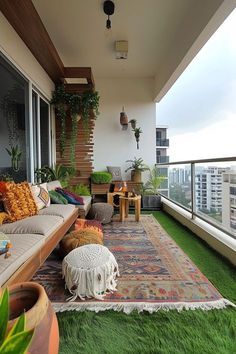 an outdoor living area with green grass and potted plants on the balcony overlooking cityscape