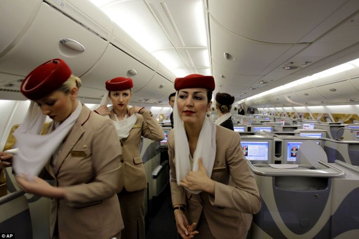 three women in air hostess uniforms on an airplane