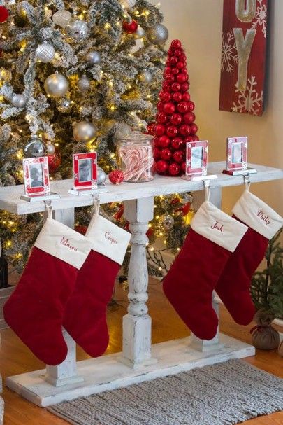 christmas stockings hanging from a table with pictures on it