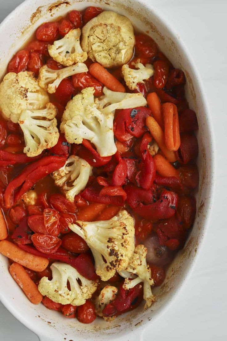 a white bowl filled with carrots and cauliflower