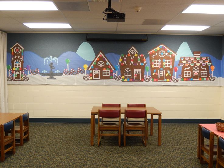 an empty classroom with desks and chairs in front of a painting on the wall