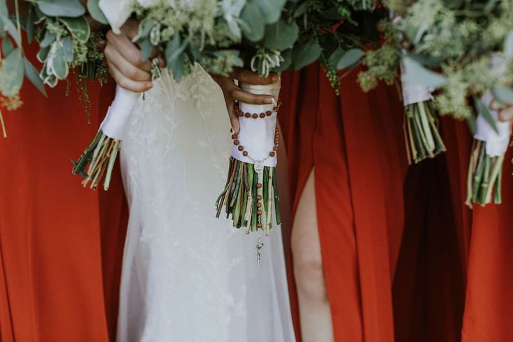 the bridesmaids are holding their bouquets with white flowers and greenery on them