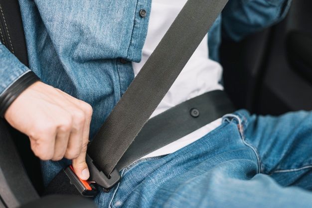 a man holding onto his seat belt while sitting in the back of a car or truck