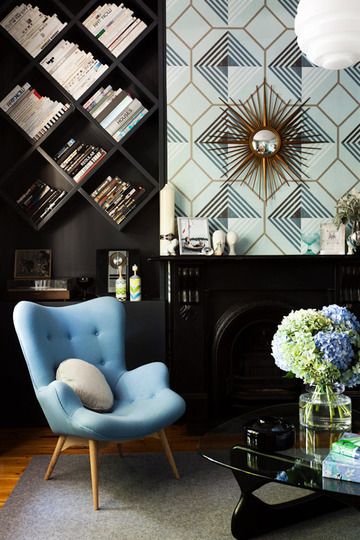 a living room filled with furniture and a fire place in front of a book shelf