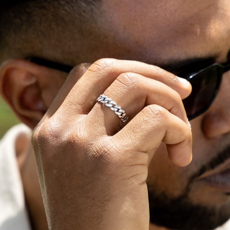 The Men's Cuban Link Chain Ring has been expertly designed and crafted to achieve the ideal size, weight, and shine while also providing a comfortable fit for everyday wear. Its timeless design makes it a versatile accessory, perfect for any occasion. Cuban Link Ring Men, Classic Rings With Adjustable Chain, Classic White Gold Chain Ring, Modern Sterling Silver Rings With Adjustable Chain, Classic Silver Rings With Chain Detail, Classic Silver Ring With Chain Detail, Modern White Gold Chain Link Rings, Classic Silver Link Rings, Classic Link Chain Ring