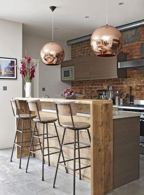 an image of a kitchen with bar stools in the center and two lights hanging from the ceiling