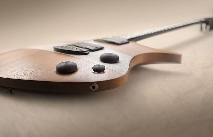 a wooden guitar with black knobs on it's head and neck, resting on a white surface