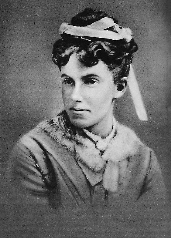 an old black and white photo of a woman with a hat on top of her head