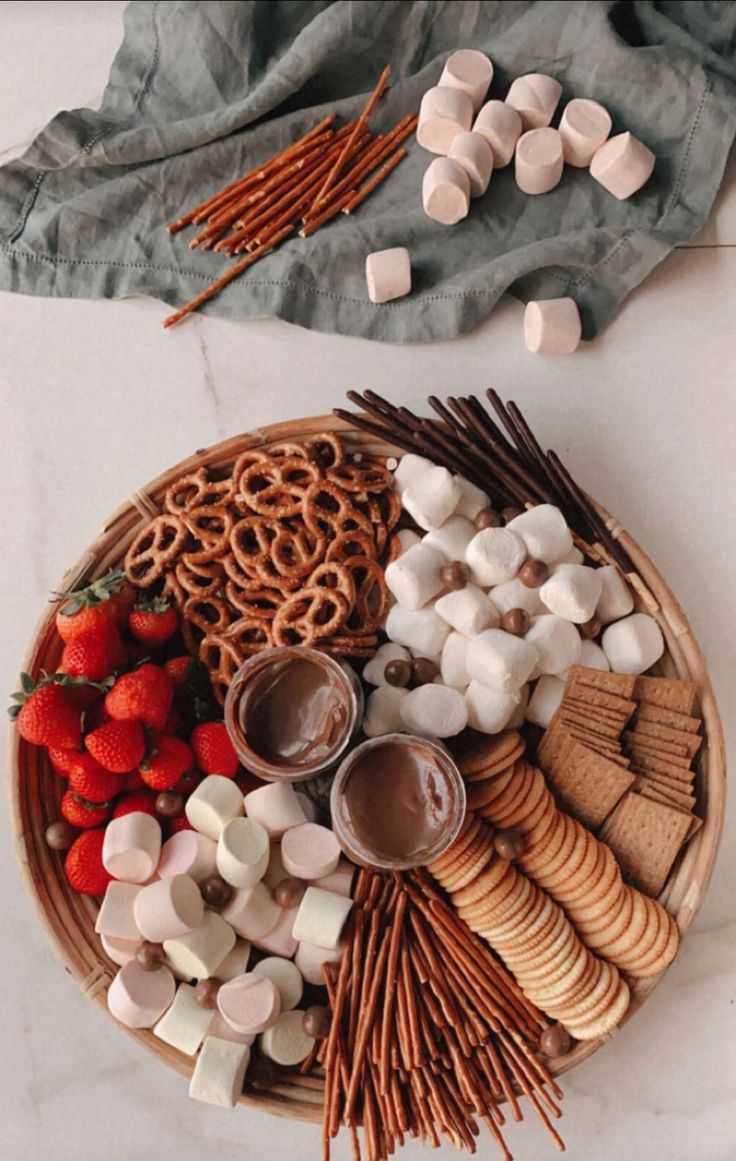 a platter with marshmallows, strawberries and pretzels