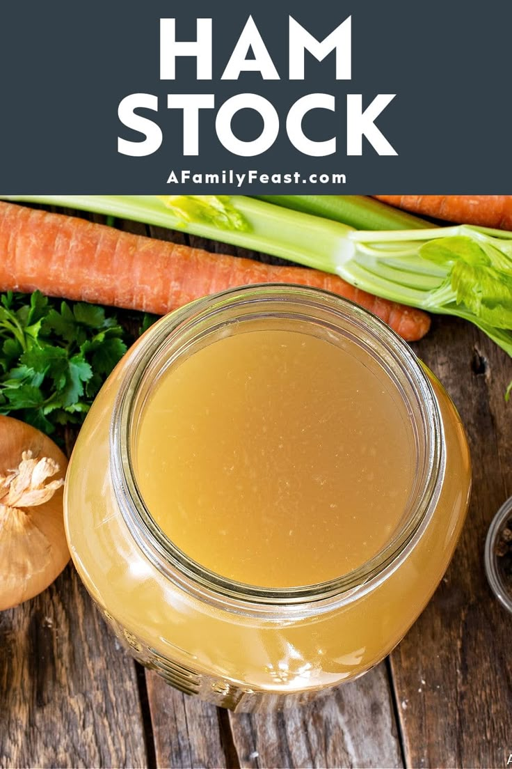 a glass jar filled with liquid next to carrots and celery