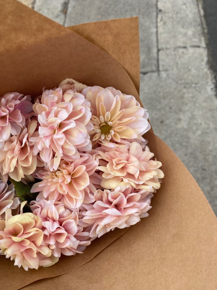 a bunch of pink flowers in a brown paper bag