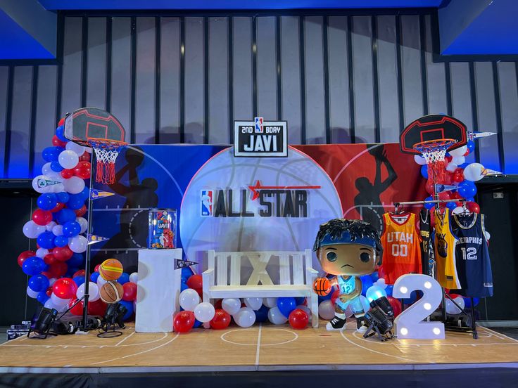 an all star basketball themed stage set up with balloons and toys on the floor for kids to play in