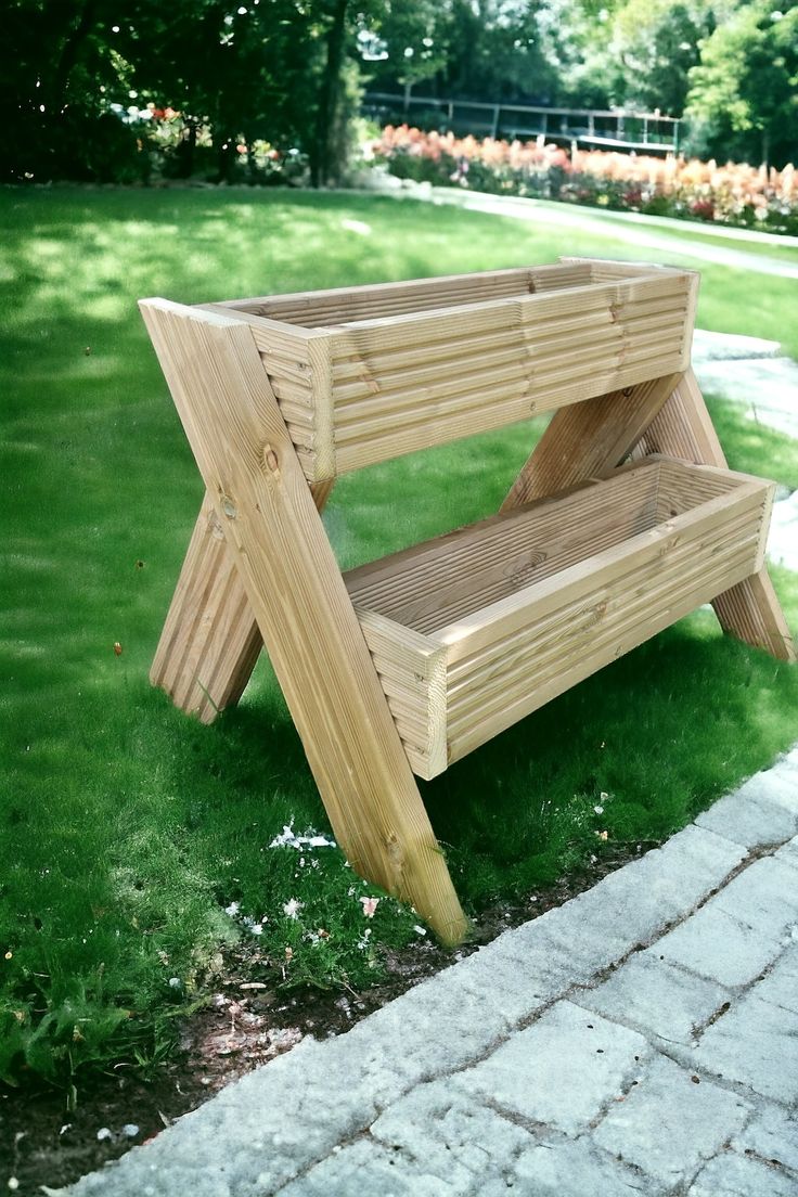 a wooden bench sitting on top of a green grass covered park area next to a brick walkway