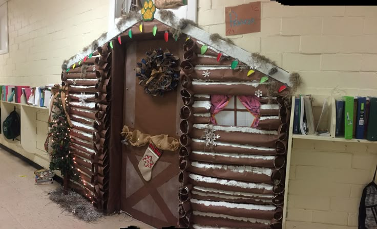 a building made out of chocolate and decorated with christmas decorations on the front door, along with bookshelves