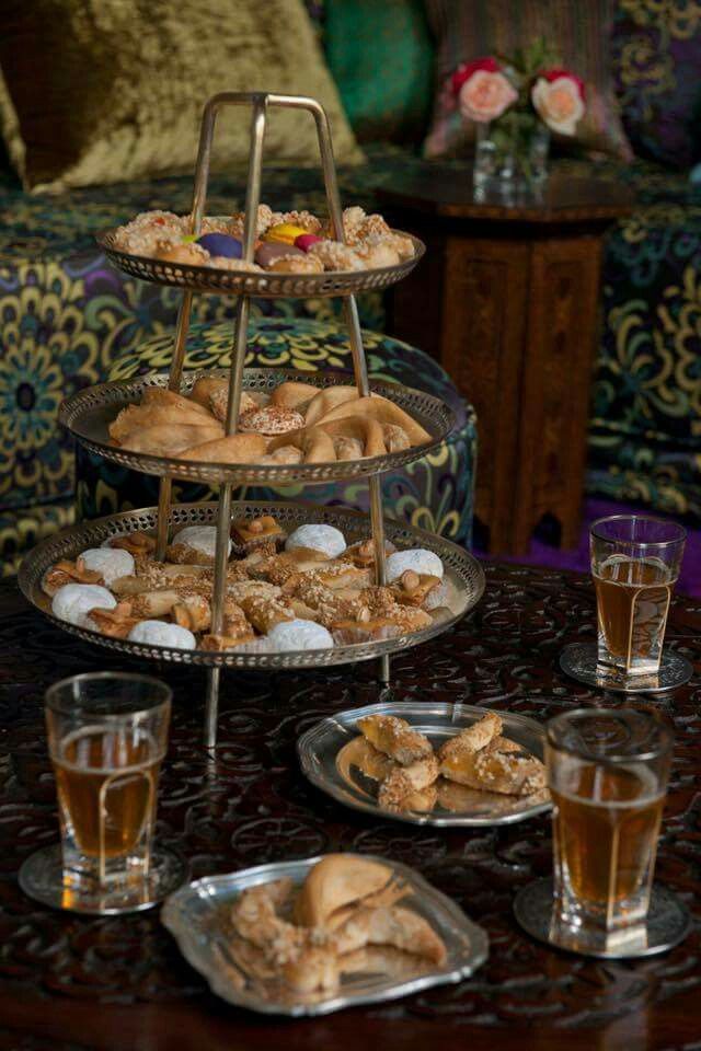 three tiered trays filled with pastries on top of a table next to drinks