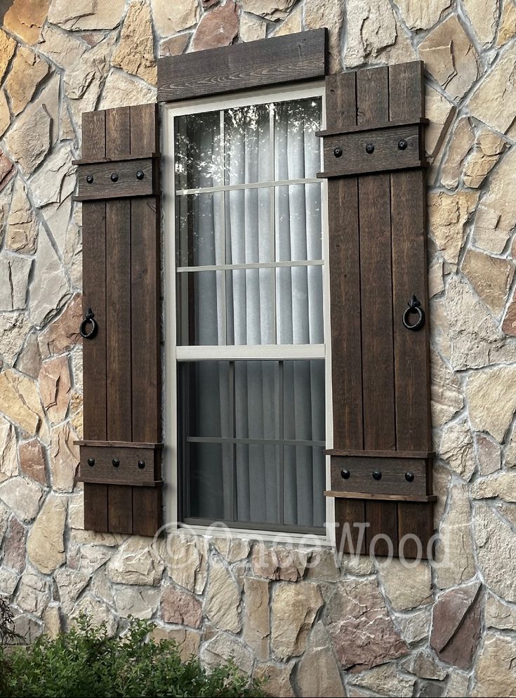 an old window with shutters on a stone building