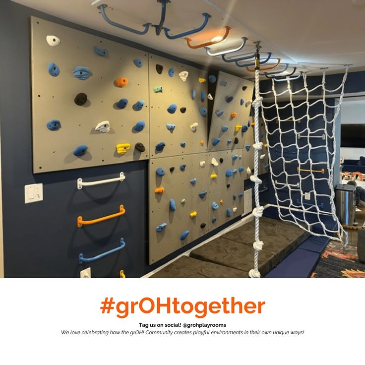 there is a climbing wall in the room with blue and yellow ropes hanging from it