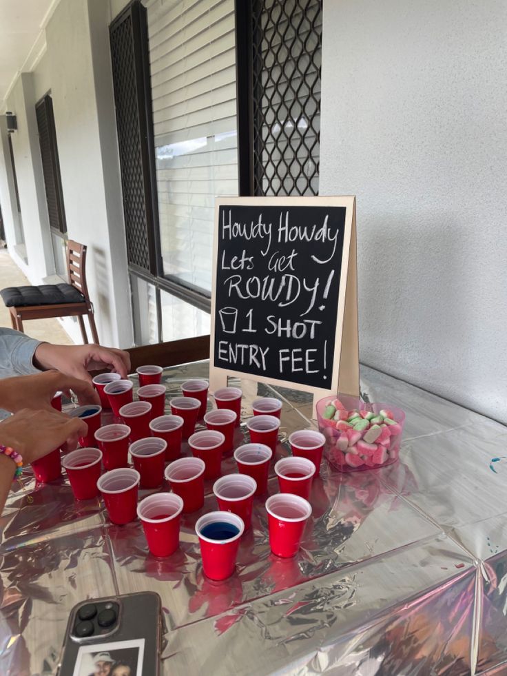 a table with red cups and a sign on it