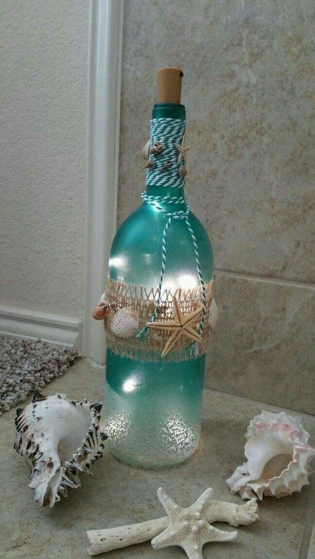 a bottle filled with sea shells sitting on top of a counter next to a starfish