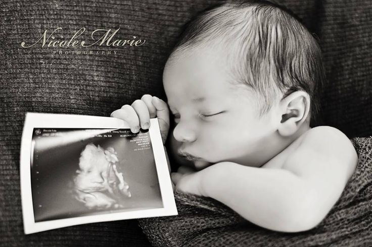 a baby is sleeping on a couch and holding a magazine