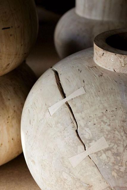 several vases with holes in them sitting on the floor