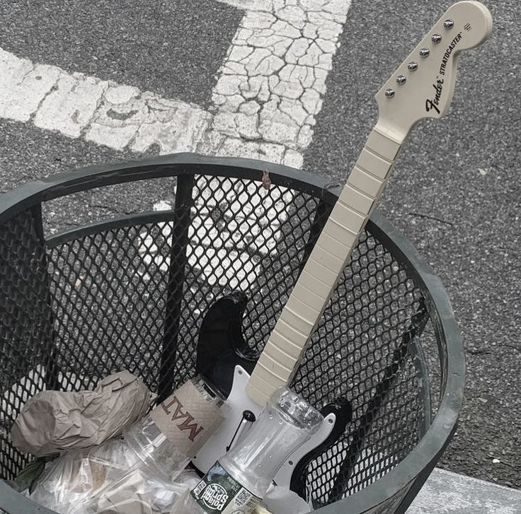 an electric guitar sitting in a trash can