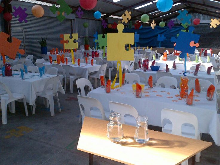 tables and chairs are set up for an event with paper decorations on the ceiling above them